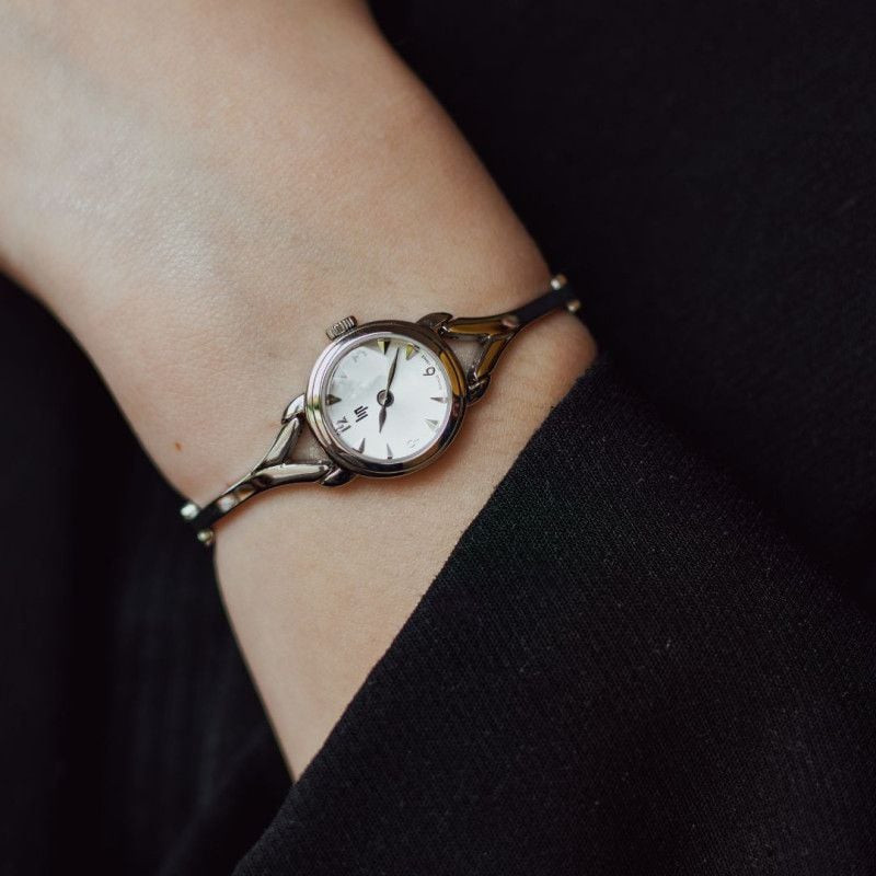 Montre analogique LIP Henriette bracelet en métal argenté portée au poignet dans un style de vie élé