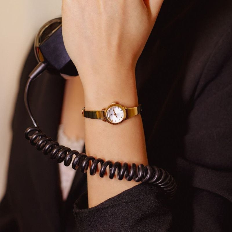 Montre analogique LIP Henriette bracelet en acier inoxydable doré portée par une femme au poignet