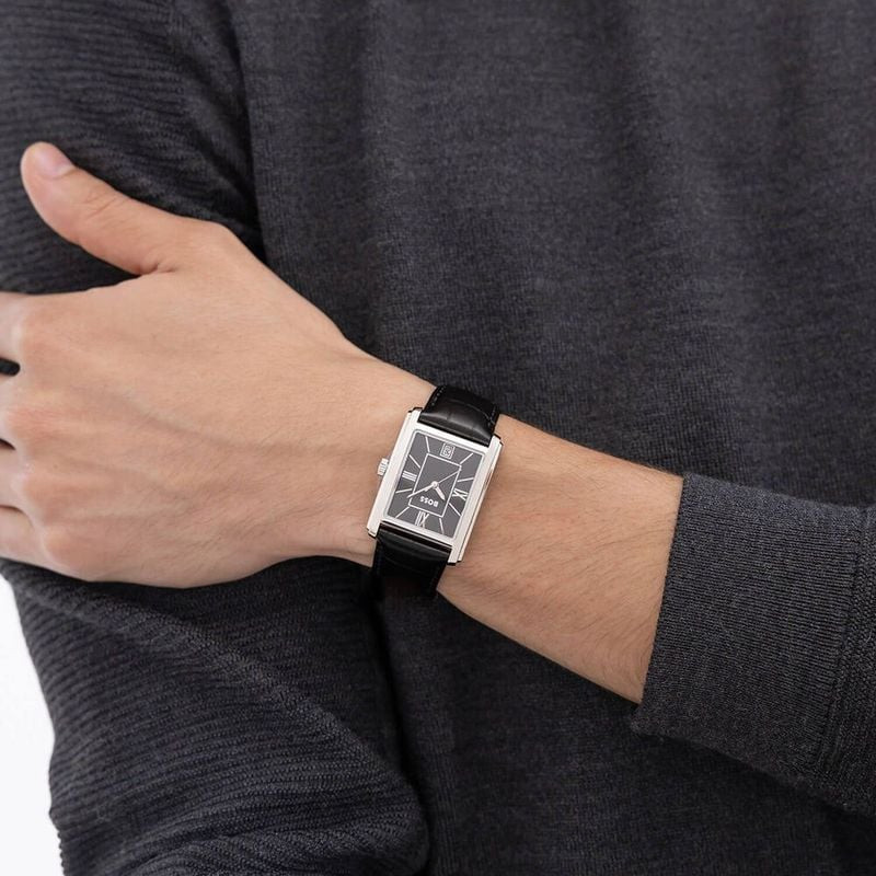 Homme en costume portant la montre BOSS Principle Dress, style élégant.