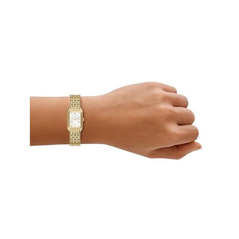 Montre Analogique FOSSIL Collection Raquel bracelet acier doré portée au poignet d'une femme en tenu