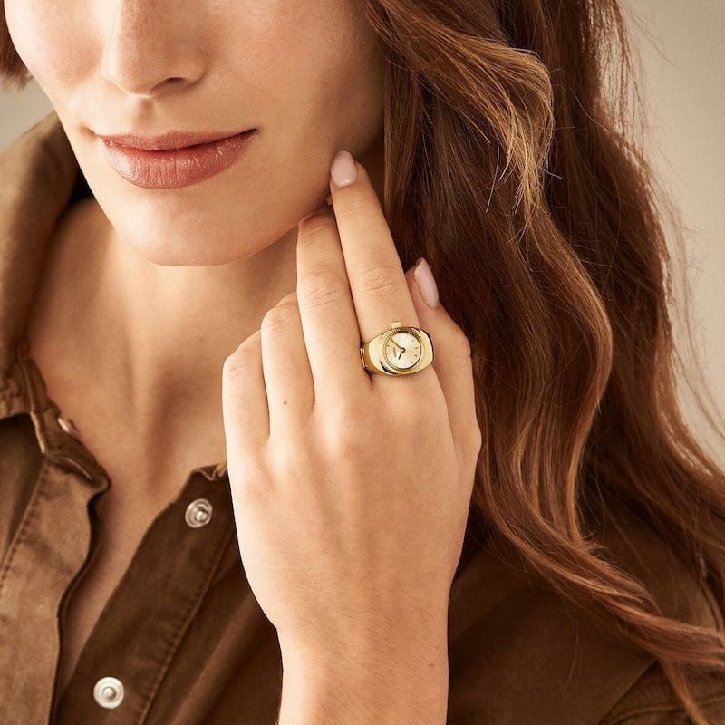Bague-montre Fossil ES5246 dorée portée au poignet d'une femme dans un style de vie