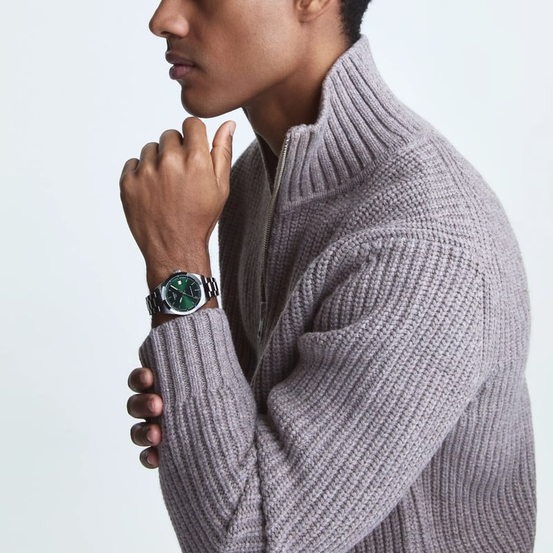Homme portant une montre automatique Tissot Gentleman 38mm à cadran vert au poignet dans un cadre dé