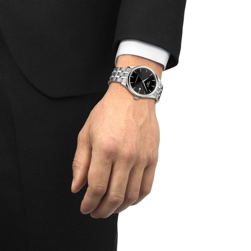 Montre Automatique TISSOT Collection Classic Dream bracelet acier gris portée au poignet dans une sc