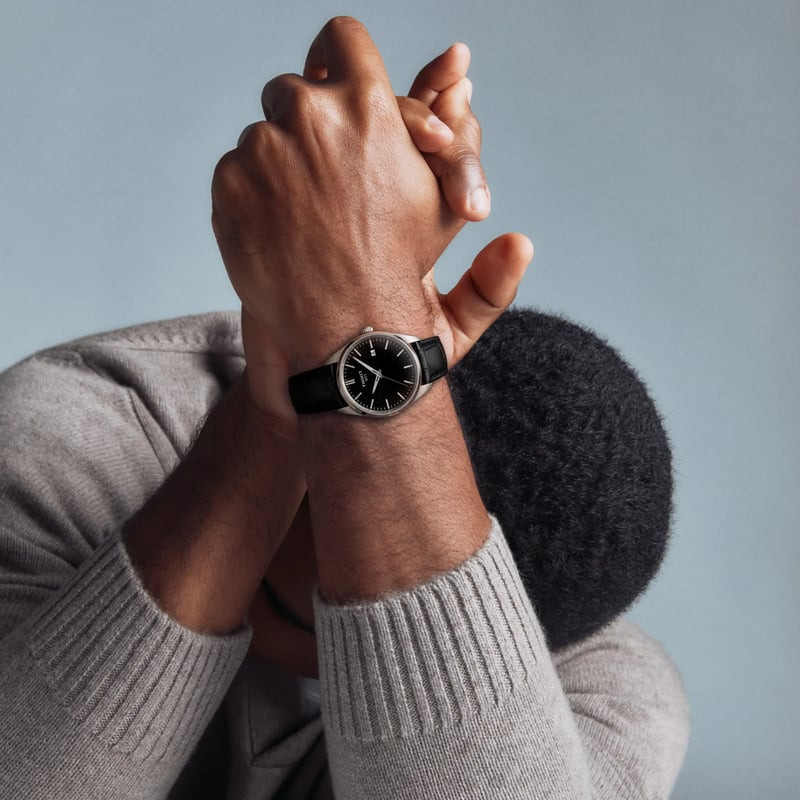 Montre Analogique Tissot Collection PR 100 Bracelet Cuir Noir portée au poignet, style élégant