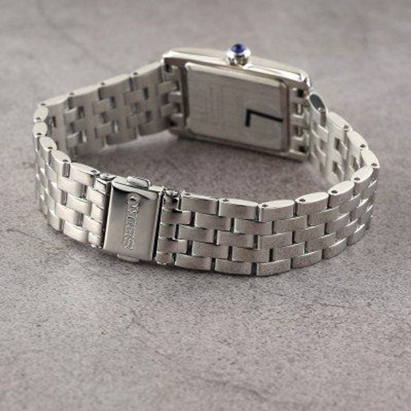 Montre Analogique SEIKO Collection Classic bracelet acier argenté posée sur une table en bois, avec 
