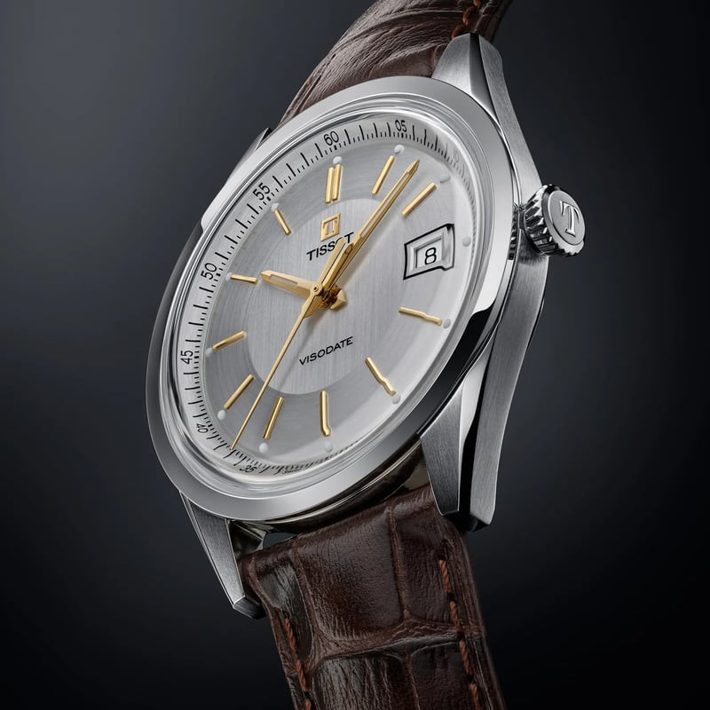 Montre Tissot Visodate 39mm automatique sur table en bois, boîtier rond classique et bracelet cuir b