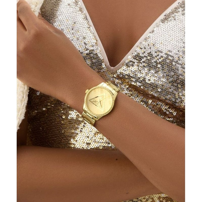Femme portant la montre GUESS Roxy dorée avec tenue chic, photographie lifestyle