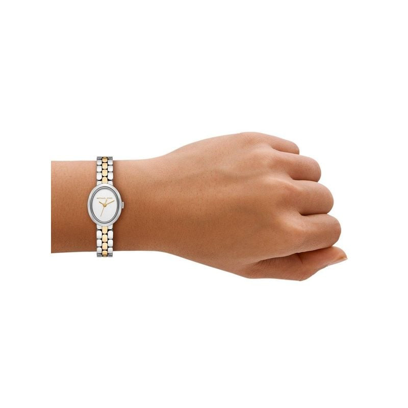 Femme élégante portant la Montre Analogique Michael Kors collection Maude bracelet acier doré au poi