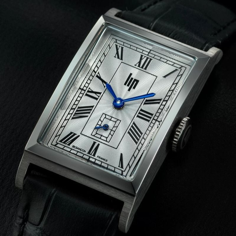 Montre Analogique LIP Churchill bracelet cuir noir posée sur un bureau en bois avec lumière douce