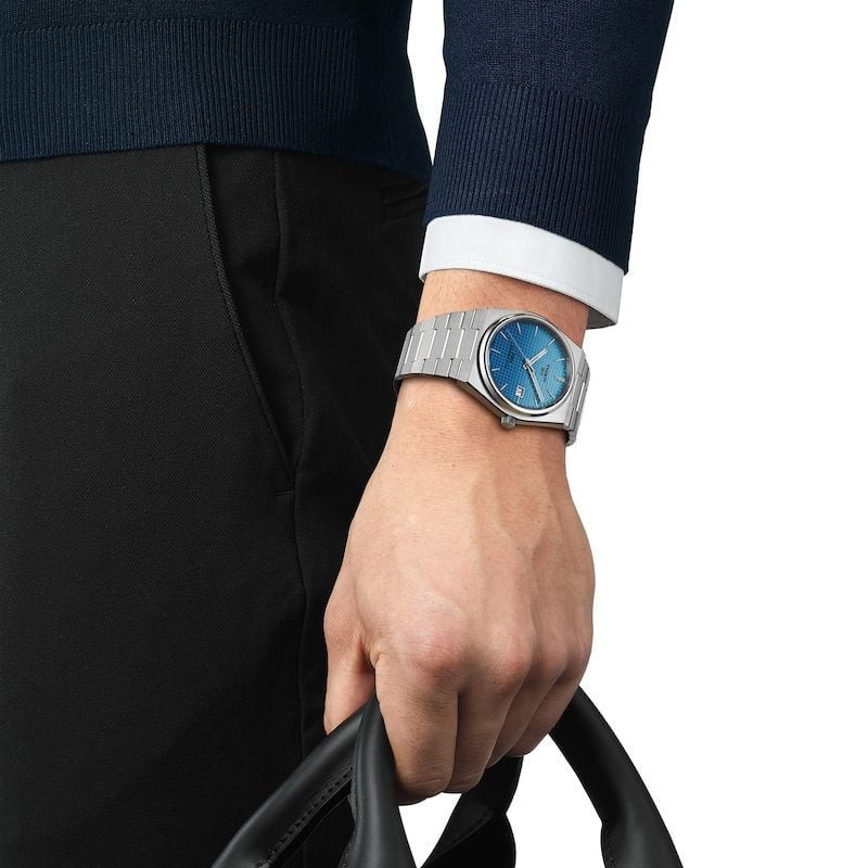 Photo lifestyle de la Montre Automatique TISSOT Collection PRX bracelet acier gris au poignet d'un h