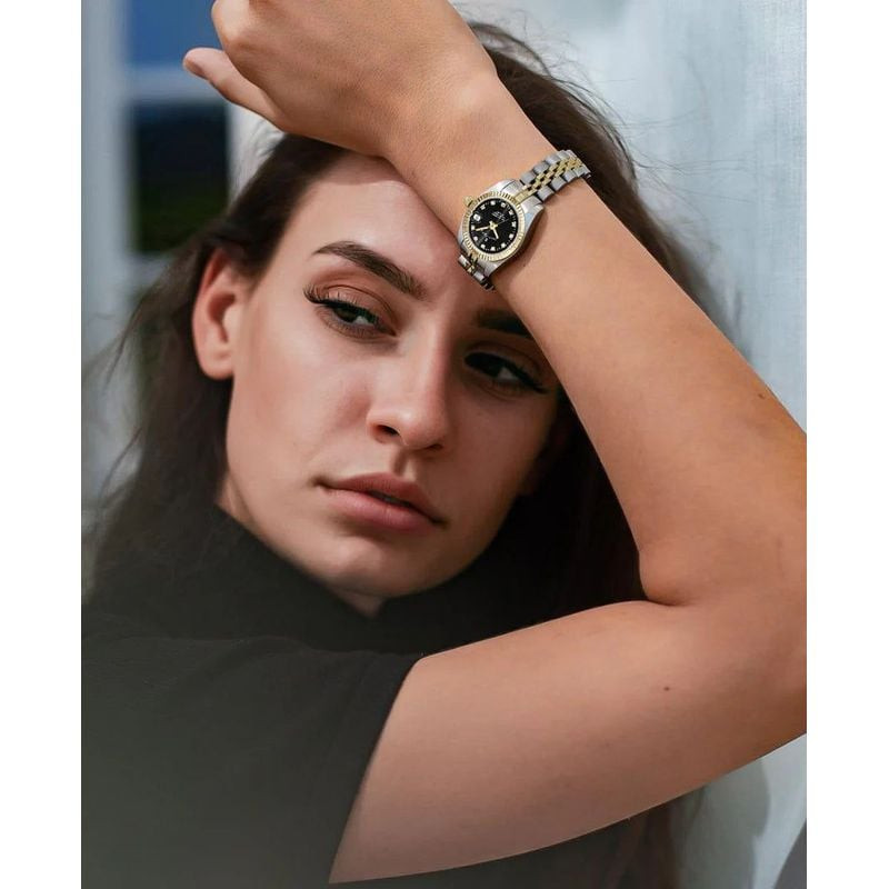 Femme portant la montre Jacques du Manoir Inspiration bicolore à son poignet en lumière naturelle