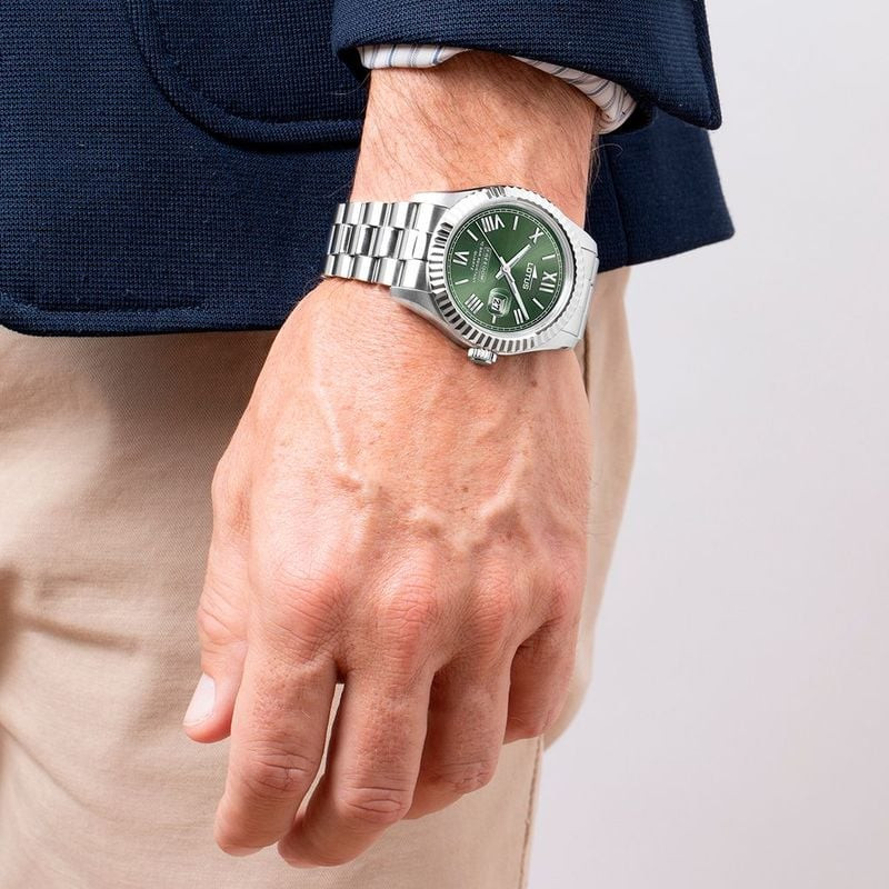 Homme portant une montre Lotus Freedom à cadran vert et bracelet en acier au poignet sur un blazer m