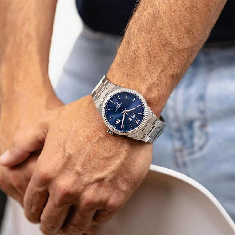 Homme portant la montre Lotus Freedom à cadran bleu et bracelet acier au poignet, tenue décontractée