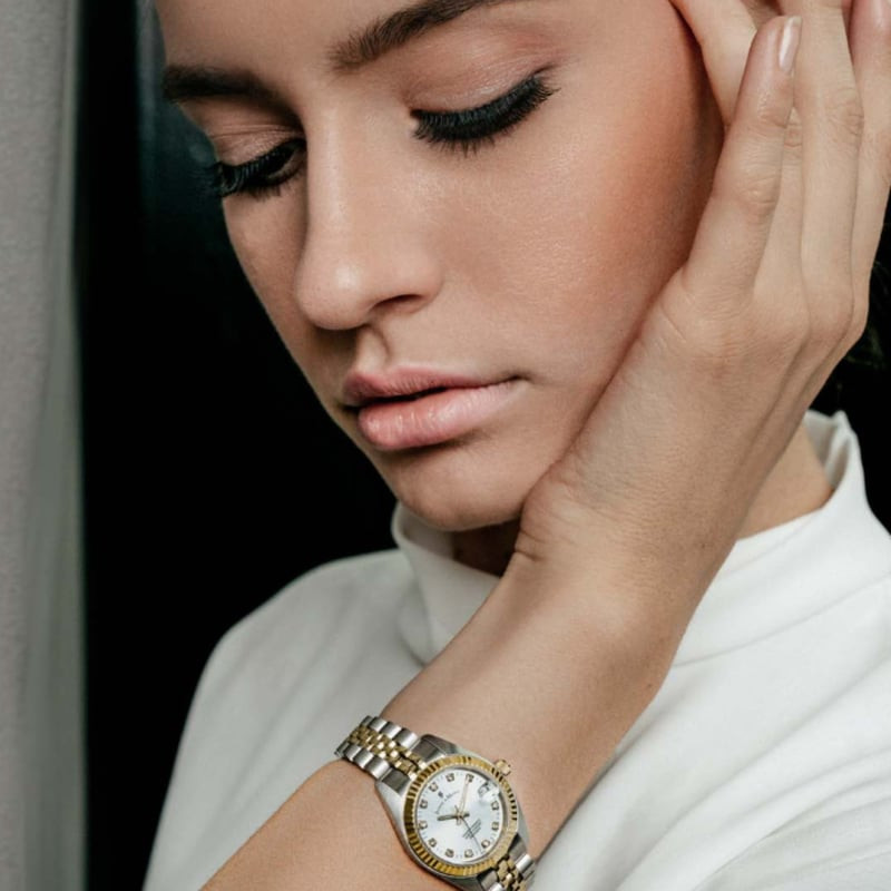 Poignet portant la Montre Analogique JACQUES DU MANOIR Collection Inspiration, bracelet acier bicolo