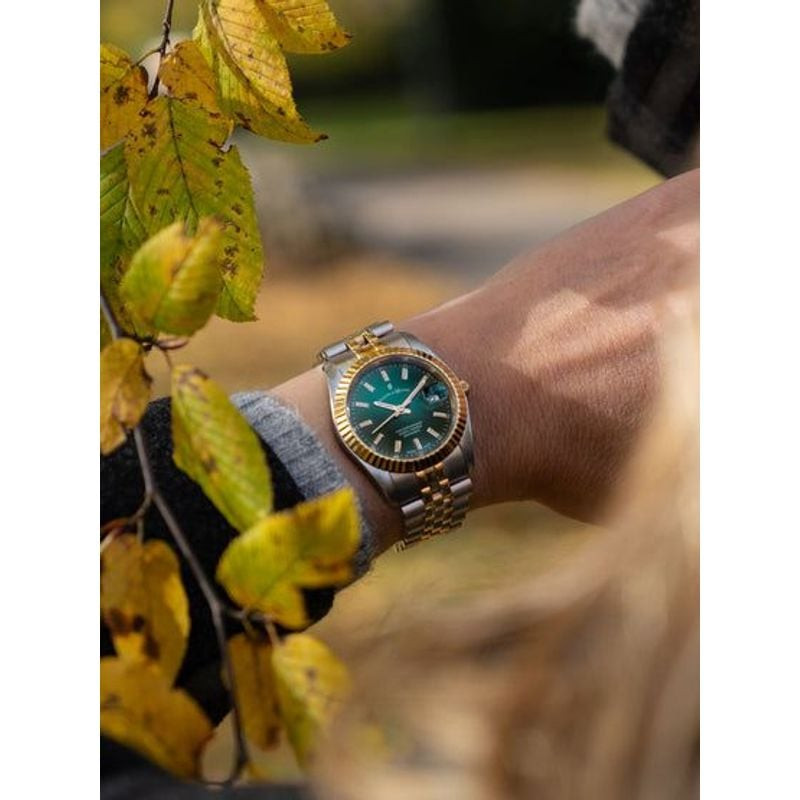 Montre Jacques Du Manoir Inspiration portée au poignet, entourée de feuilles d'automne dorées en ext