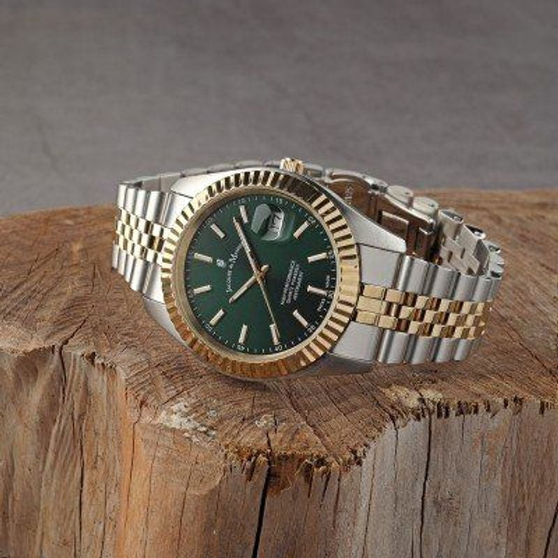 Montre Jacques Du Manoir Inspiration à cadran vert posée sur bois rustique, index dorés