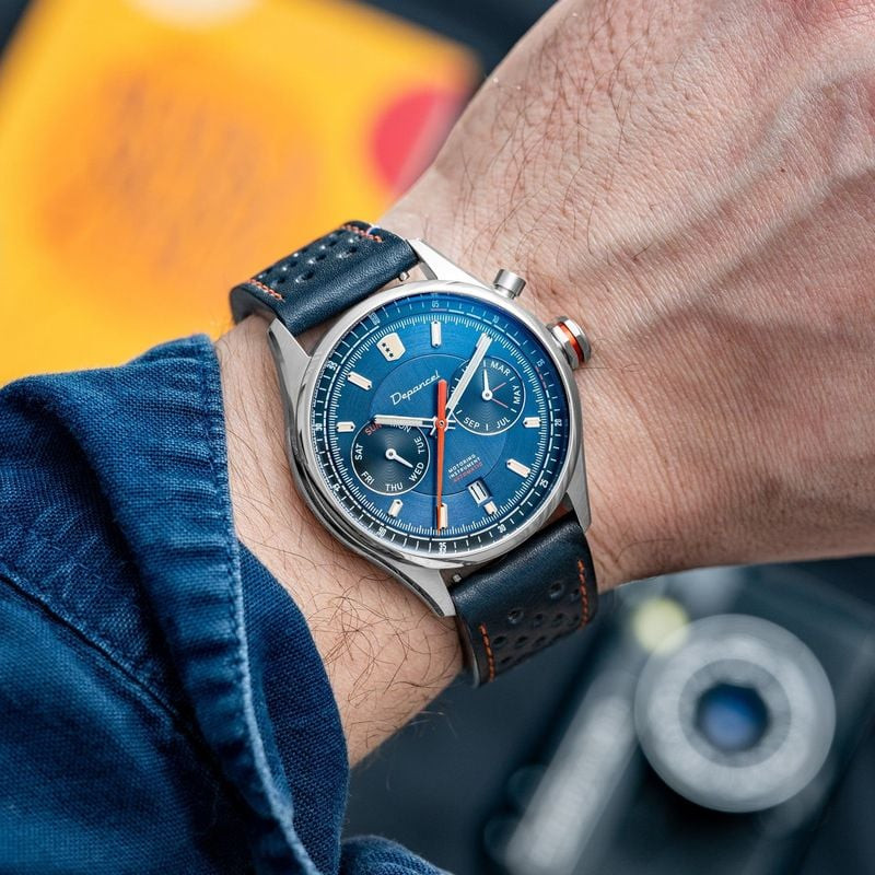 Montre automatique Depancel Autosport Blue portée au poignet avec une veste en jean bleu et un brace
