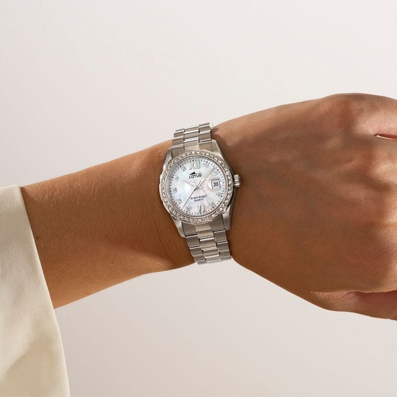 Montre femme Lotus Freedom portée au poignet, cadran nacré, lunette sertie de zircons et bracelet en