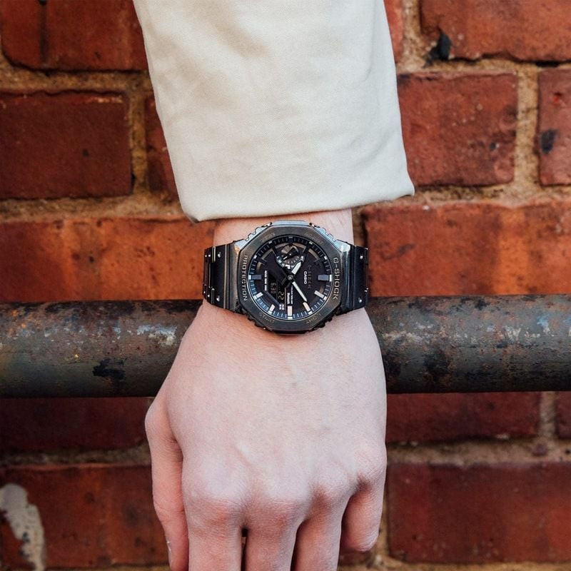 Montre Connectée G-SHOCK Collection 2100 bracelet acier noir au poignet d'un homme élégant en milieu