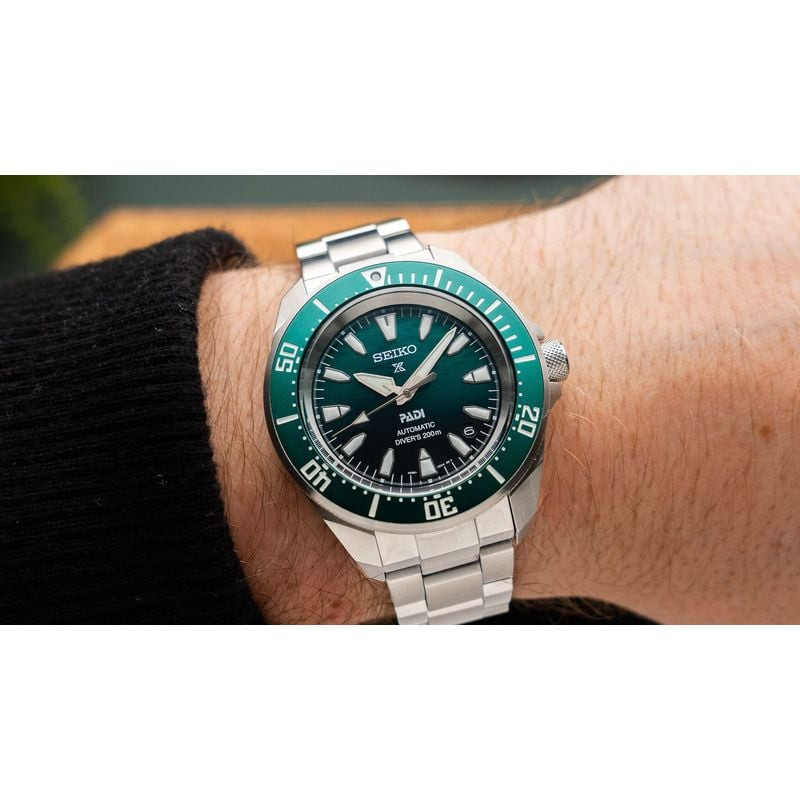 Montre de plongée Seiko Prospex Samurai PADI édition spéciale verte au poignet d'un homme en pull no