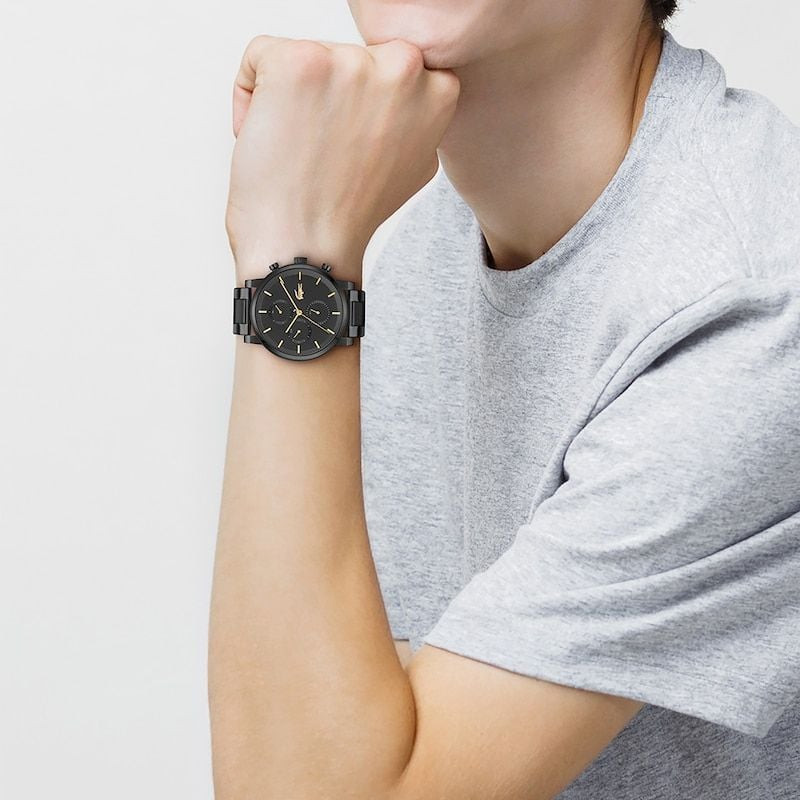 Homme portant la Montre Analogique LACOSTE collection Replay bracelet acier noir lors d'une sortie u