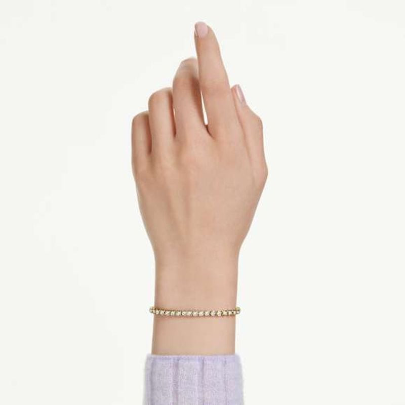 Bracelet tennis Matrix Swarovski doré blanc porté au poignet, éclatant dans une ambiance élégante.