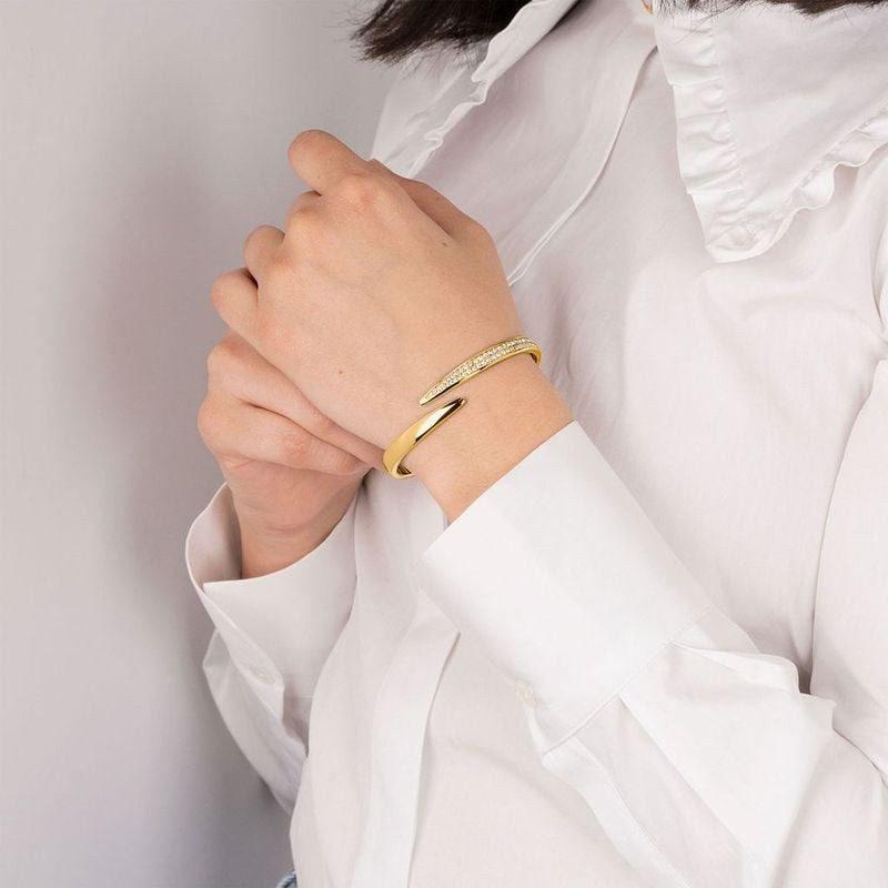 Modèle portant le bracelet rigide Lotus Style Bliss en acier doré avec cristaux, associé à une chemi