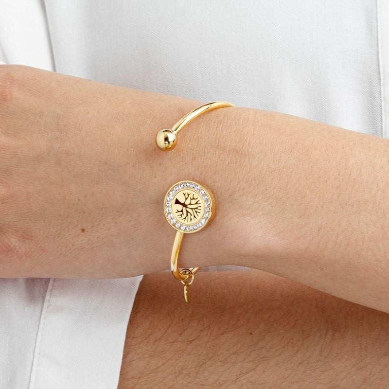 Bracelet jonc Lotus Style doré porté au poignet d'une femme, médaillon Arbre de Vie et design ouvert