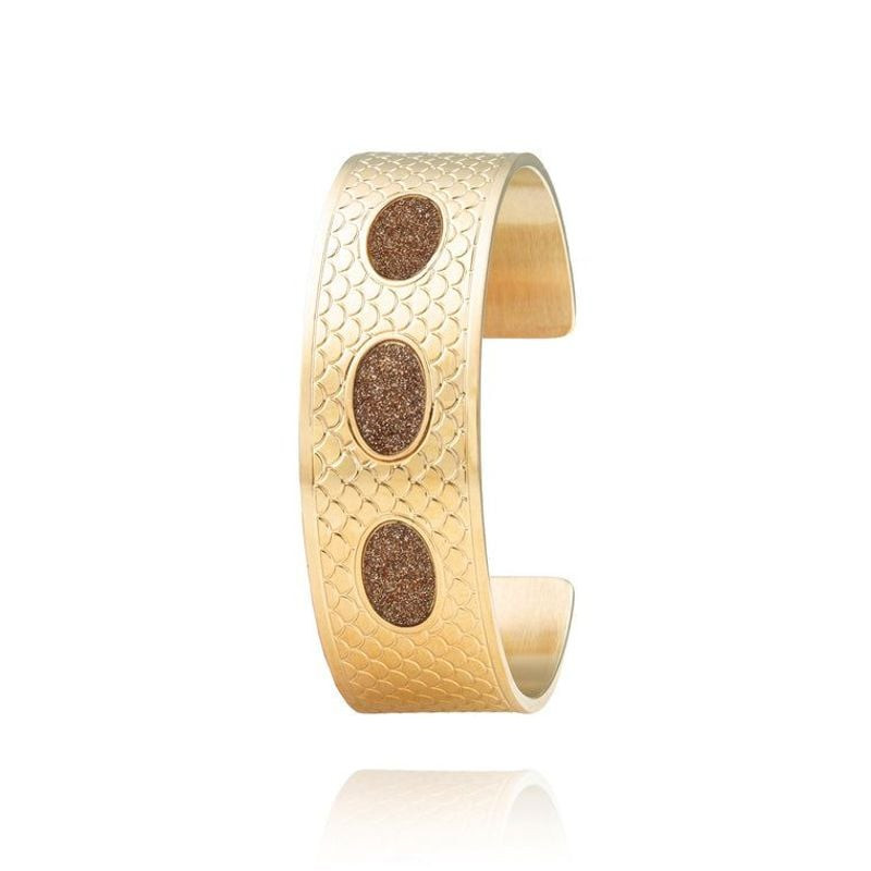 Bracelet manchette ouvert doré avec relief d'écailles gravées et trois médaillons ovales sur fond bl