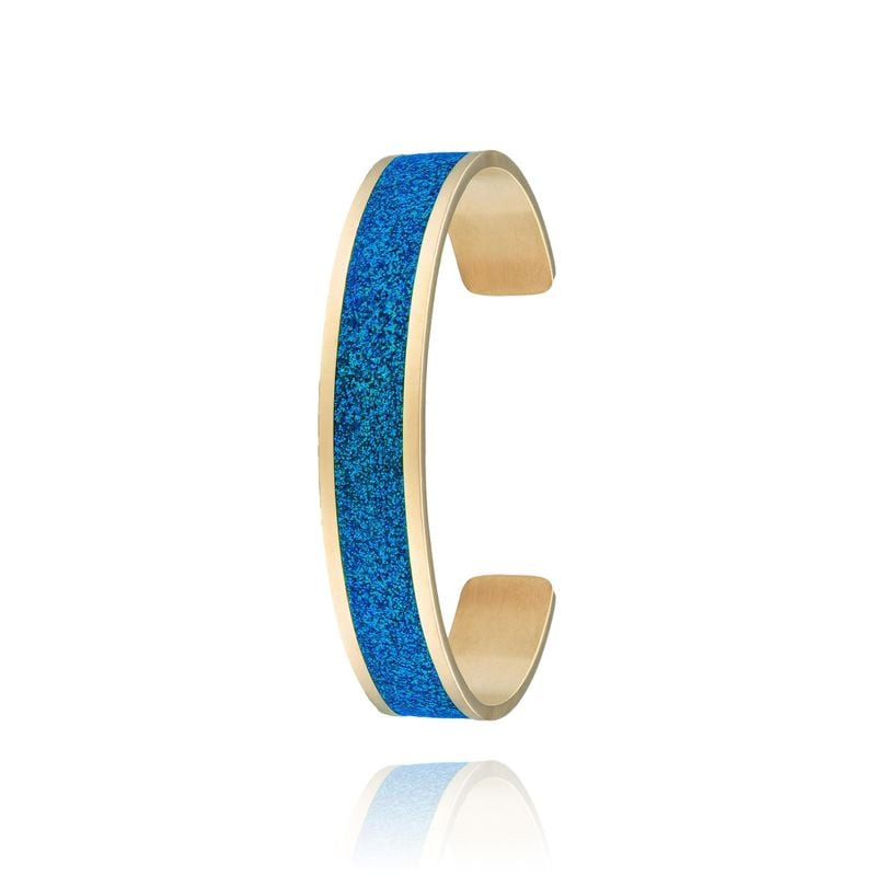 Vue de profil d'un jonc ouvert doré avec incrustation de strass bleu lagon et reflet sur fond blanc.