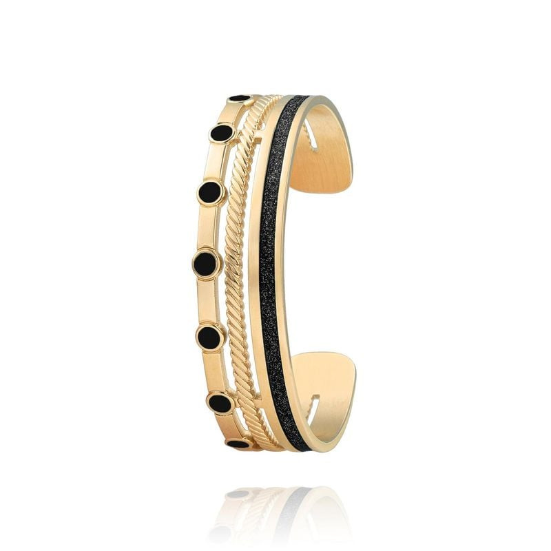 Bracelet manchette doré multi-rangs avec points d'émail noir et bande noire scintillante sur fond bl