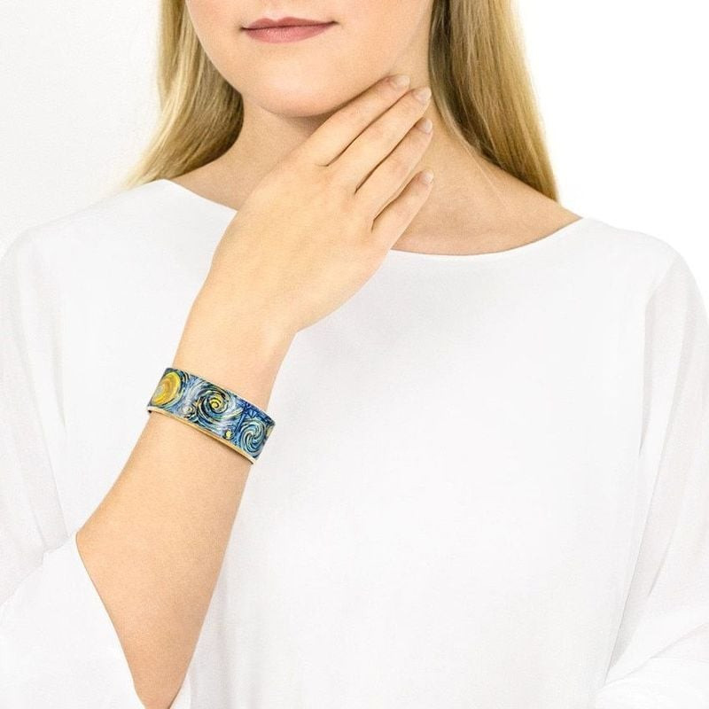 Femme portant le bracelet cerclé FREYWILLE Éternité en émail à feu, motif bleu et or inspiré de Van 