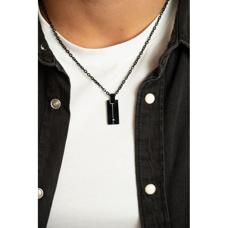 Homme portant un collier PHEBUS en acier noir avec pendentif diamant sur t-shirt blanc et chemise so
