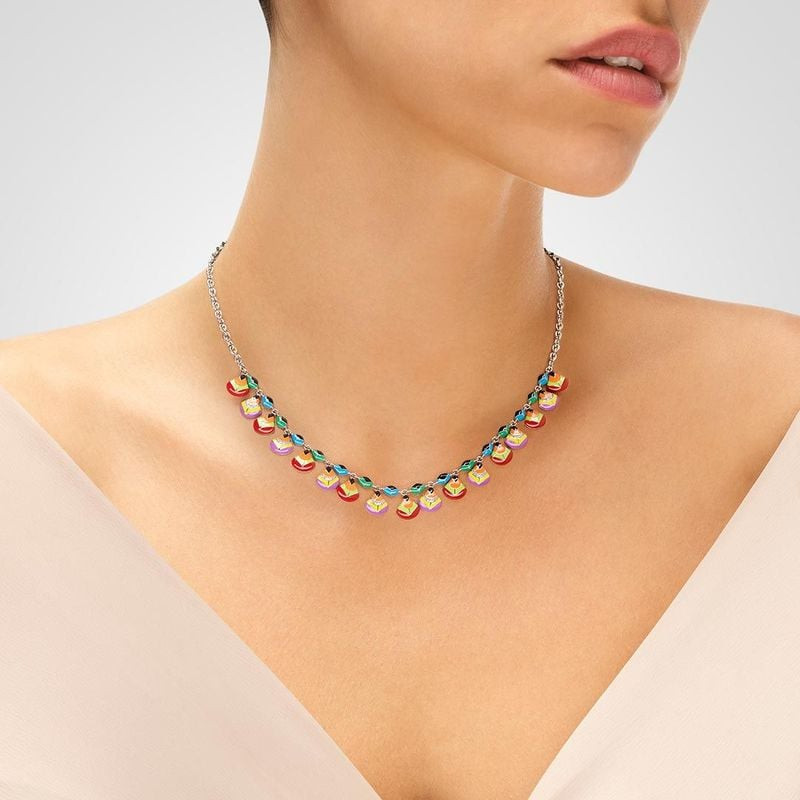 Gros plan du collier UNA STORIA Plumes porté sur le cou d'un mannequin avec un haut col V blanc et d