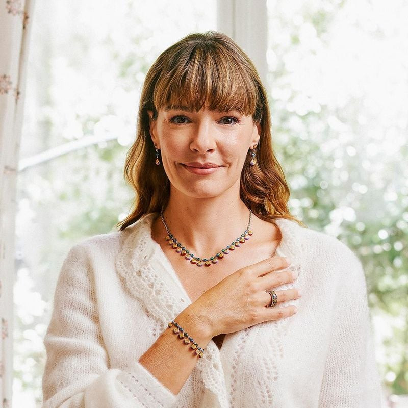 Femme en cardigan blanc en maille portant le collier en argent UNA STORIA Plumes, boucles d'oreilles
