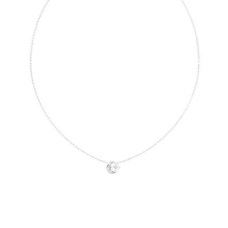 Gros plan sur le pendentif lune en acier rhodié du collier Guess Aurora avec un cristal transparent.
