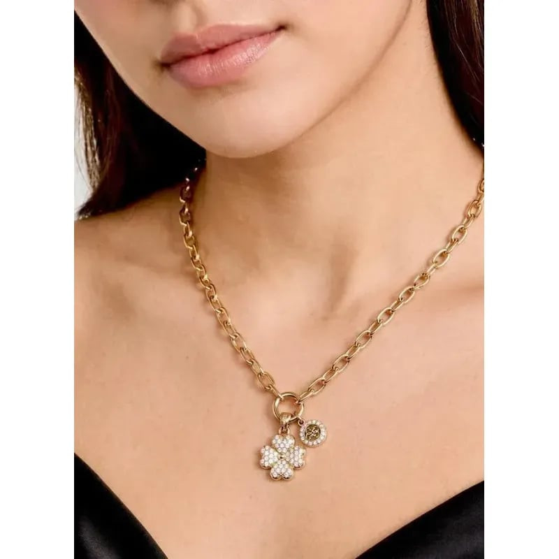 Collier Guess Love Bites Trèfle Pavé Acier Doré porté par un mannequin, mettant en valeur le charm t