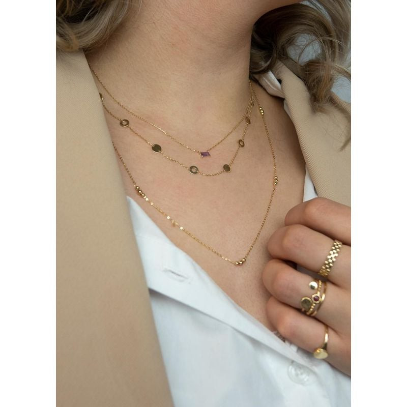 Femme en blazer beige et chemise blanche avec le collier Jackie Gold Medina en or 14K et améthyste, 