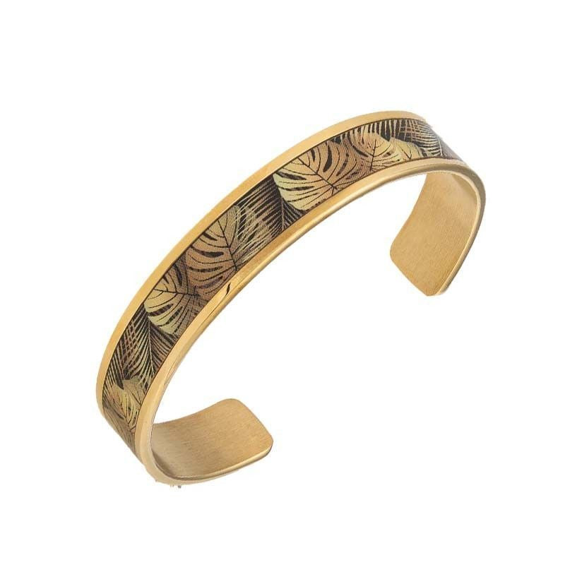 Vue inclinée du bracelet manchette ouvert en acier inoxydable, gravure de feuille Monstera dorée sur