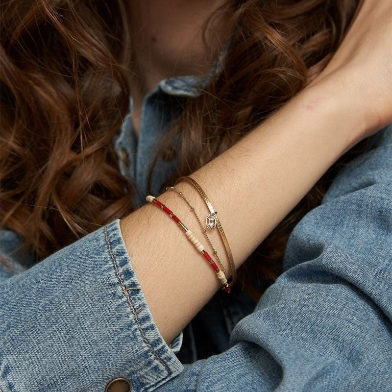 Femme portant le bracelet Appoline empilé à son poignet avec une veste en jean bleu et des cheveux o