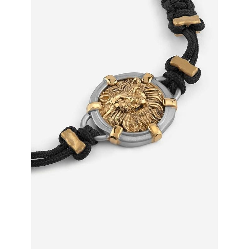 Gros plan sur la médaille tête de lion argentée du bracelet GUESS Lion Legacy, avec des accents doré