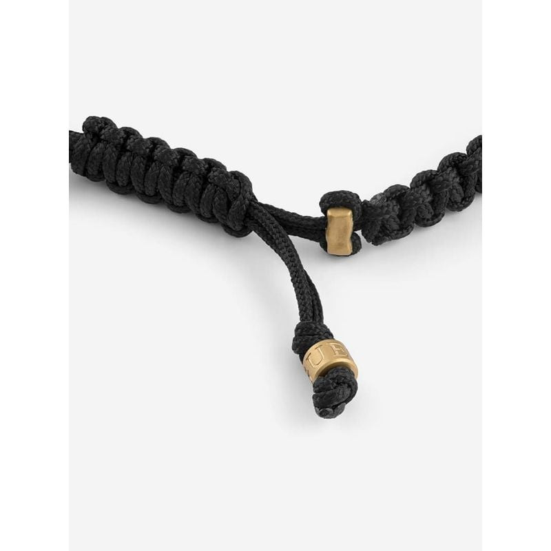 Bracelet GUESS Lion Legacy à fermeture coulissante réglable, perles gravées dorées et détail de cord