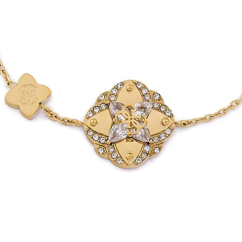 Détail du bracelet chaîne GUESS Wild Flower en acier doré avec cristaux et pendentif filigrane.