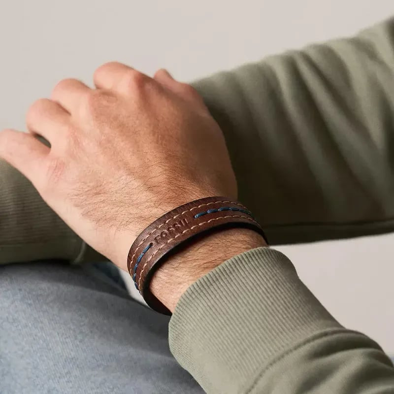Bracelet cuir marron Fossil Everett argenté porté au poignet dans une ambiance lifestyle élégante.