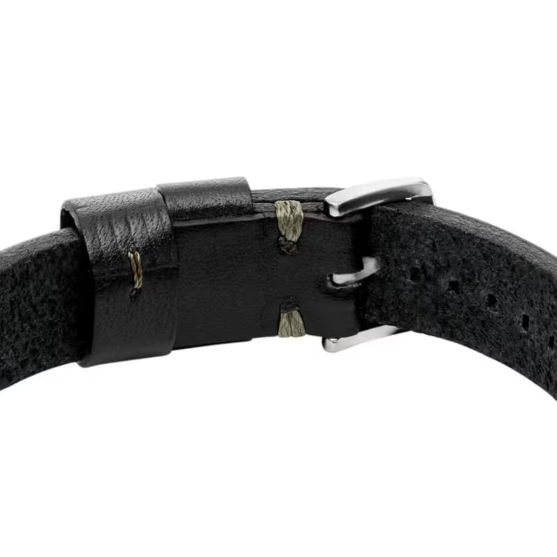 Détail du bracelet Fossil Machine en cuir noir avec surpiqûres dorées et rivets chromés.