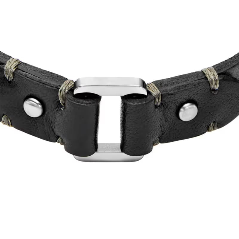 Gros plan sur le bracelet Fossil Machine en cuir noir avec surpiqûres dorées et rivets chromés.