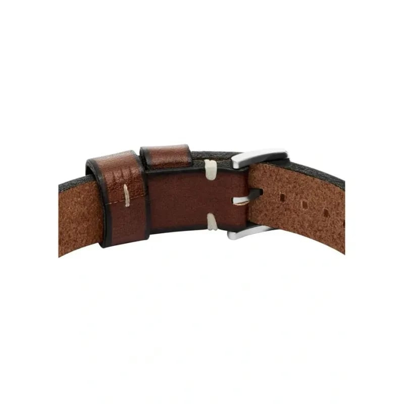 Gros plan sur le bracelet Fossil Machine en cuir marron, coutures, passants et détail de la goupille