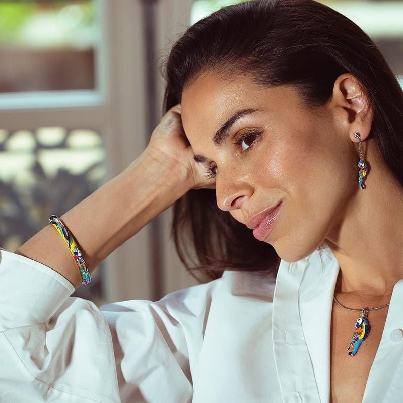 Femme élégante portant le Bracelet jonc UNA STORIA Lovebird argenté multicolore, motif perroquet col