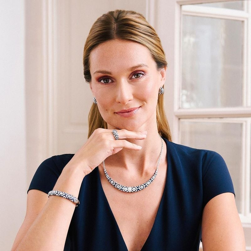 Femme portant un haut bleu marine et le bracelet jonc UNA STORIA Aztec en argent avec une parure en 