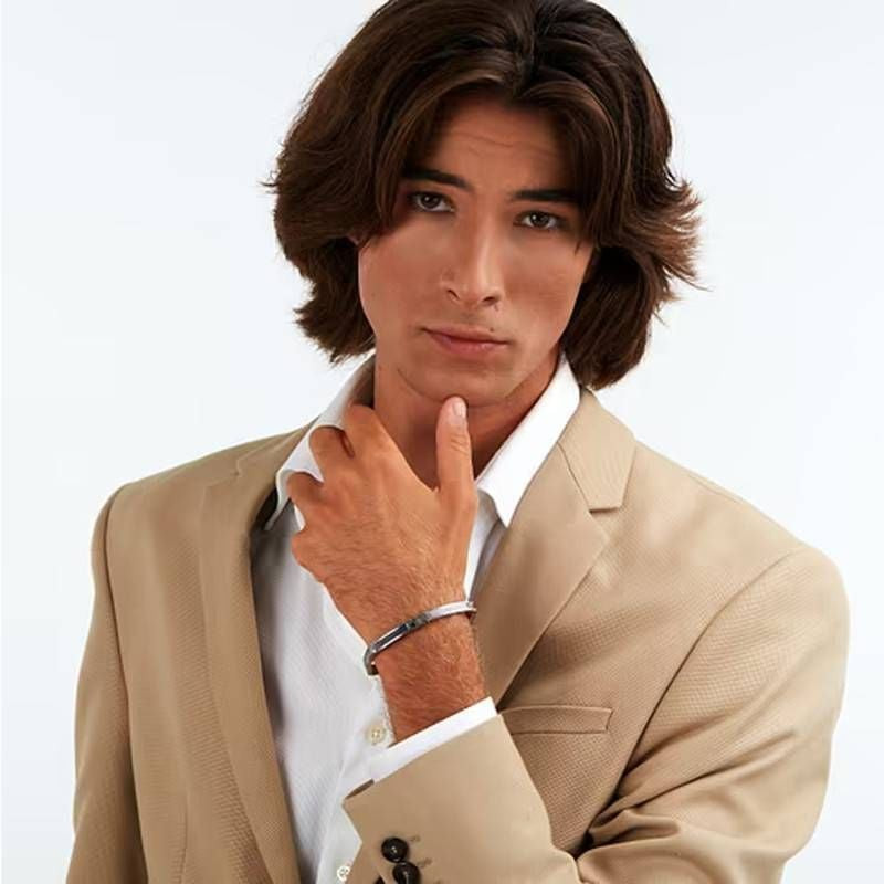 Mannequin en blazer beige et chemise blanche portant le bracelet Maserati Iconic en acier IP bleu au